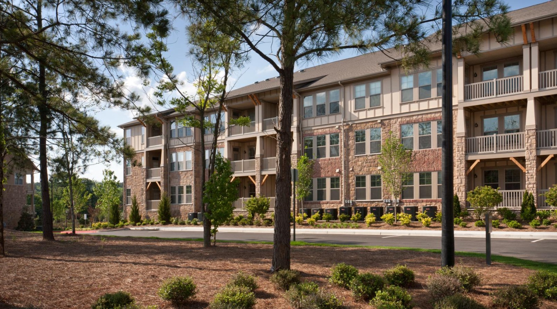 Find your perfect fit at The Regency at Johns Creek Walk a building with trees and grass